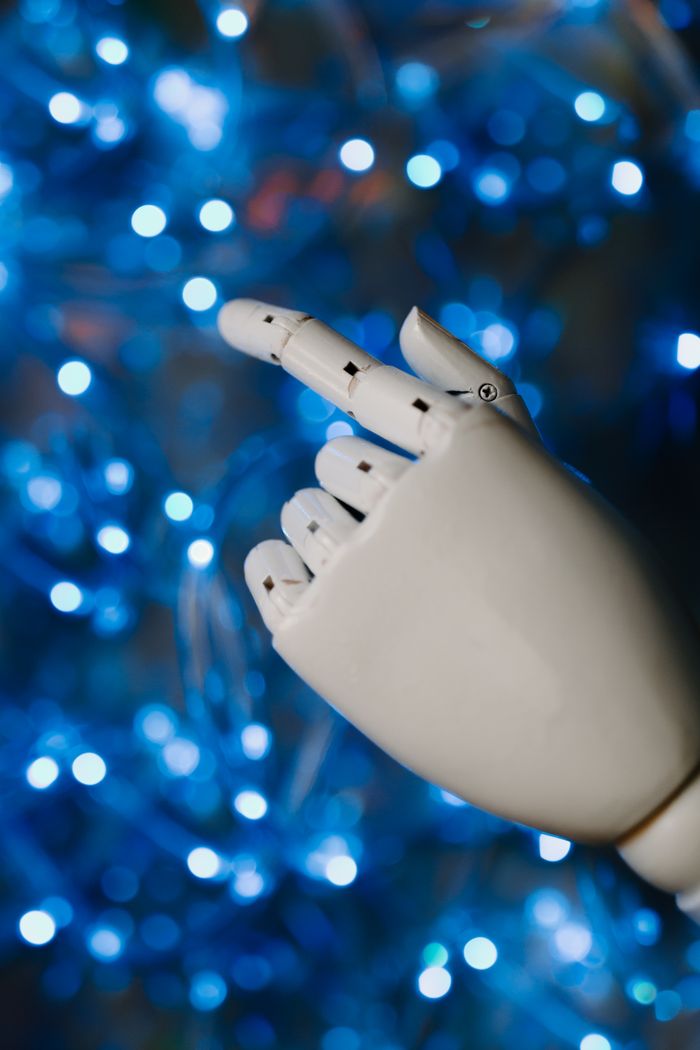 gallery-2 Close-up of a robotic hand with glowing blue bokeh background, symbolizing advanced technology.